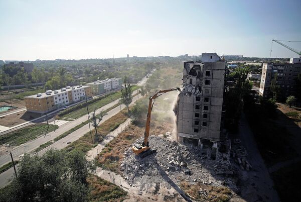 Phá dỡ một trong những tòa nhà cao tầng cuối cùng còn sót lại ở Mariupol. Gần đó là những tòa nhà mới ba tầng (phố Shevchenko) - Sputnik Việt Nam