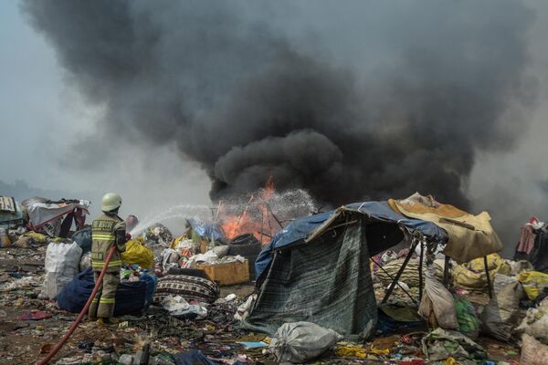 Lính cứu hỏa cố gắng dập tắt đám cháy đã cháy suốt 5 ngày tại bãi rác ở Sarimukti, ngoại ô Bandung, Tây Java, gây ô nhiễm không khí cho khoảng 12.000 người ở khu vực xung quanh. - Sputnik Việt Nam