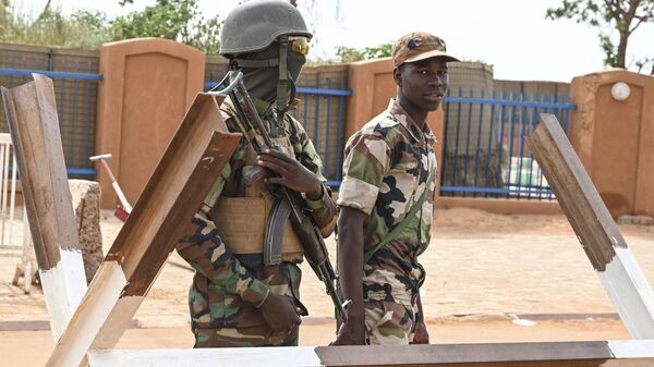 Binh lính Niger canh gác khi những người ủng hộ Hội đồng Quốc gia Bảo vệ Tổ quốc Niger (CNSP) biểu tình bên ngoài căn cứ không quân Niger và Pháp ở Niamey ngày 30/8/2023 đòi Pháp rút quân đội khỏi Niger - Sputnik Việt Nam