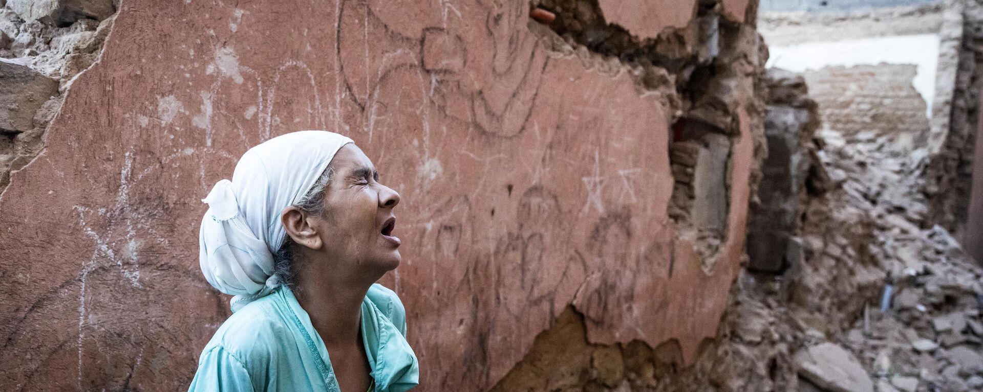 Một người phụ nữ đứng trước ngôi nhà bị hư hại do động đất ở thành phố cổ Marrakech - Sputnik Việt Nam, 1920, 10.09.2023