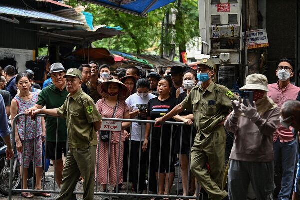 Cư dân đứng sau rào chắn bên cạnh hiện trường vụ cháy chung cưmini ở Hà Nội - Sputnik Việt Nam