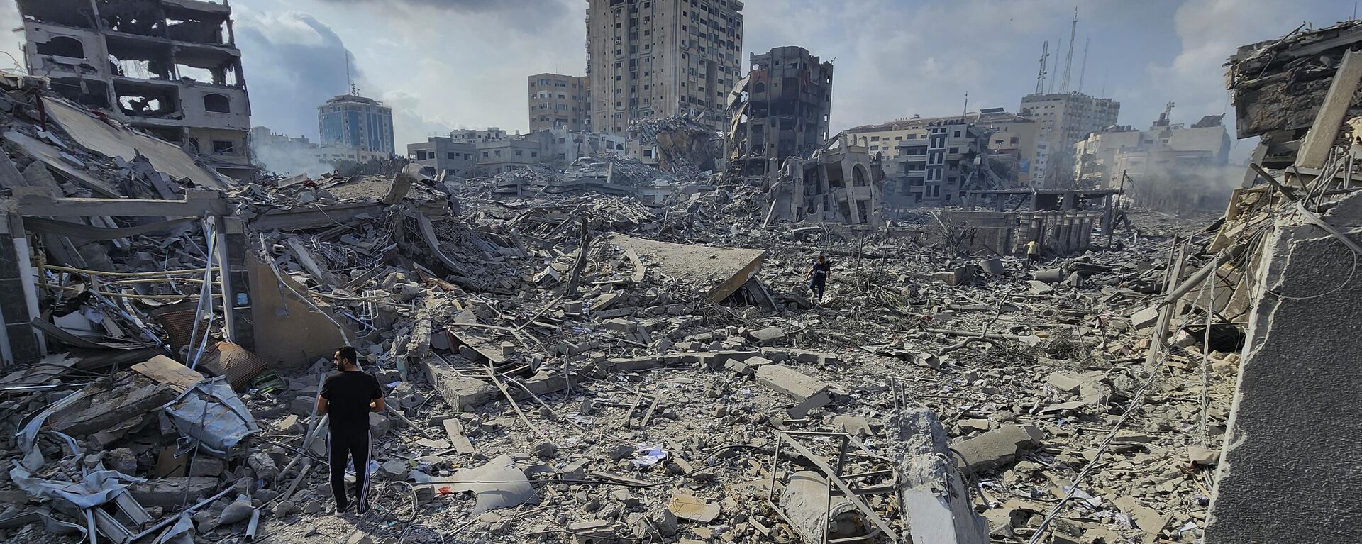 Người Palestine đi qua đống đổ nát của các tòa nhà bị phá hủy trong cuộc không kích của Israel tại thành phố Gaza, ngày 10 tháng 10 năm 2023 - Sputnik Việt Nam, 1920, 18.10.2023