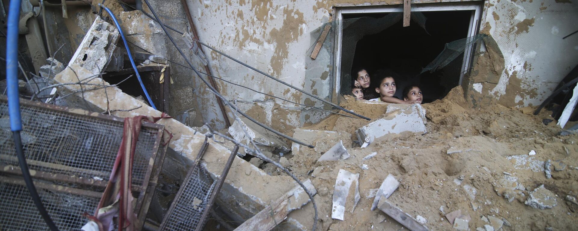 Trẻ em Palestine nhìn từ dưới đống đổ nát của một tòa nhà bị phá hủy do các cuộc không kích của Israel ở Rafah, Gaza - Sputnik Việt Nam, 1920, 02.11.2023