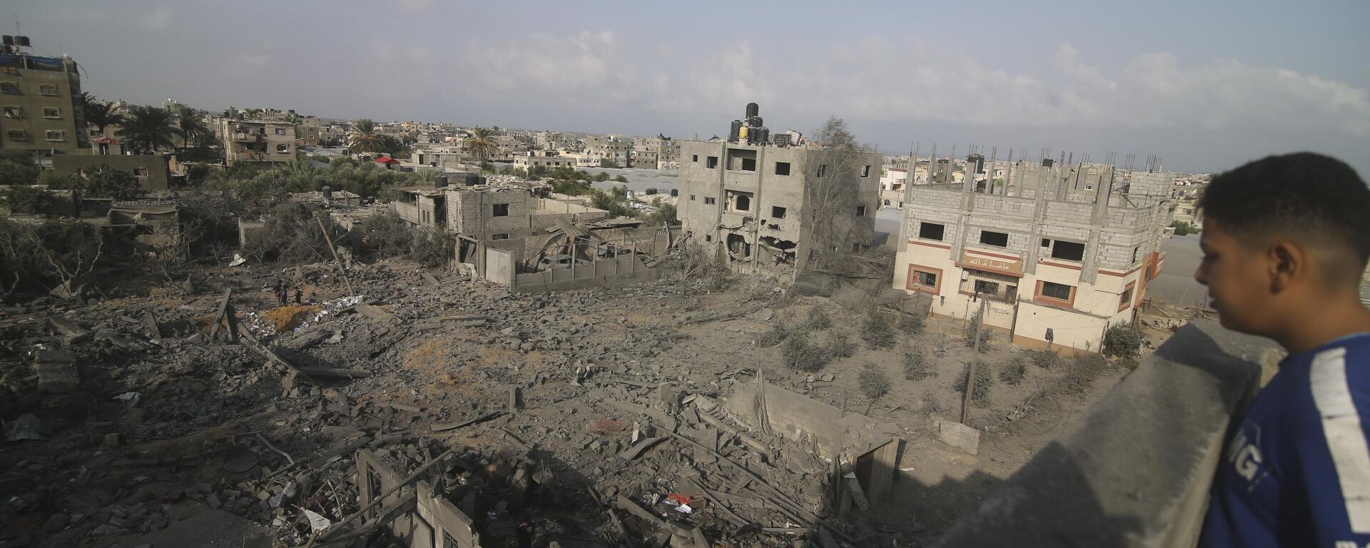 Cậu bé nhìn những tòa nhà bị phá hủy do cuộc ném bom của Israel vào Dải Gaza ở Rafah - Sputnik Việt Nam, 1920, 24.10.2023