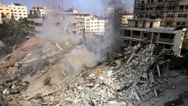 Khói bốc lên từ đống đổ nát tòa nhà bị phá hủy sau cuộc không kích của Israel ở Thành phố Gaza - Sputnik Việt Nam