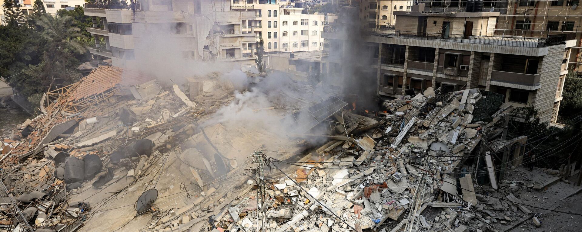Khói bốc lên từ đống đổ nát tòa nhà bị phá hủy sau cuộc không kích của Israel ở Thành phố Gaza - Sputnik Việt Nam, 1920, 08.11.2023