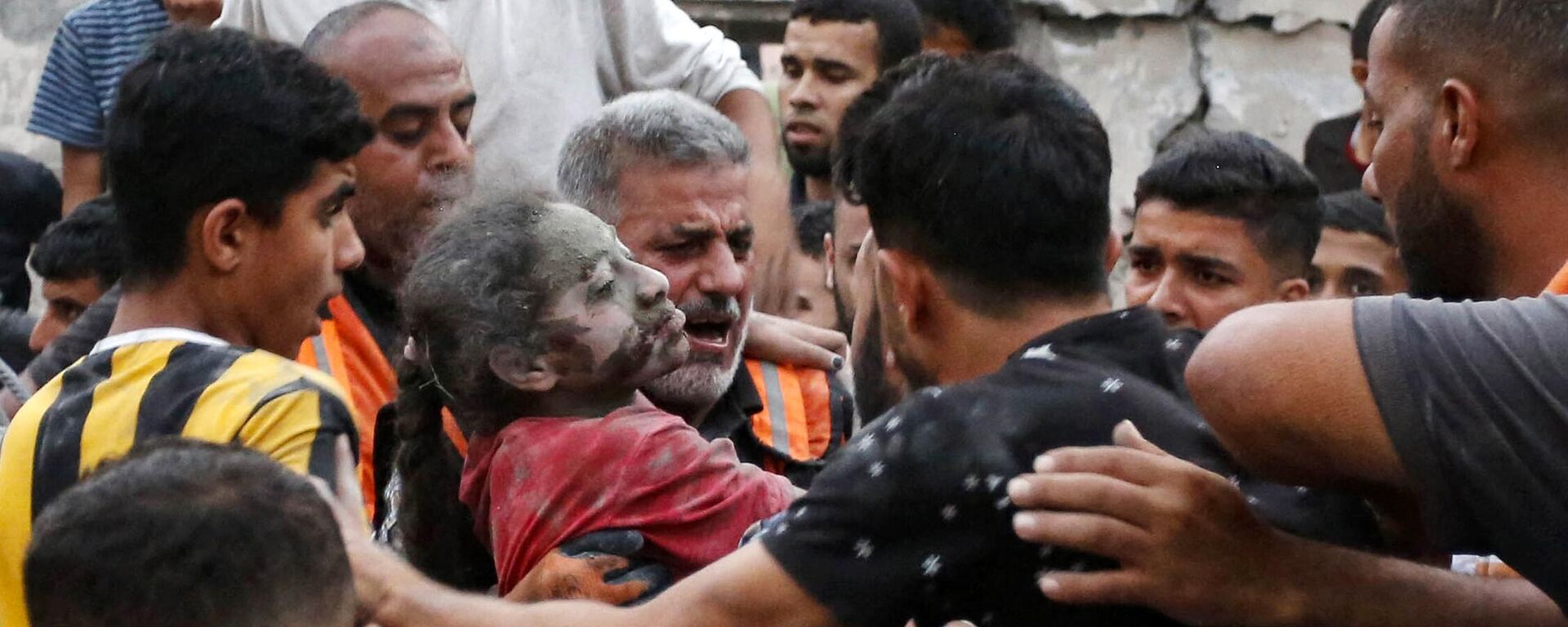 Một người đàn ông mang một bé gái bị thương từ dưới đống đổ nát của một tòa nhà bị sập sau cuộc tấn công của Israel tại thành phố Deir Al-Balah ở khu vực trung tâm của Dải Gaza - Sputnik Việt Nam, 1920, 31.10.2023