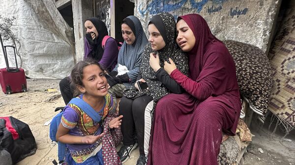 Những người Palestine trước đống đổ nát nhà của gia đình sau cuộc không kích của Israel tại Dải Gaza - Sputnik Việt Nam
