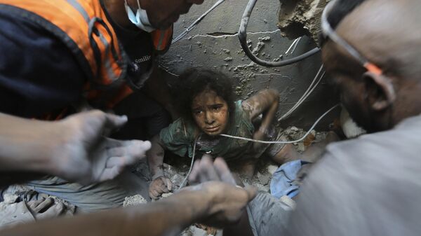Người Palestine cố gắng kéo một bé gái ra khỏi đống đổ nát của một tòa nhà bị phá hủy bởi các cuộc không kích của Israel tại trại tị nạn Jabaliya, phía bắc Gaza. - Sputnik Việt Nam