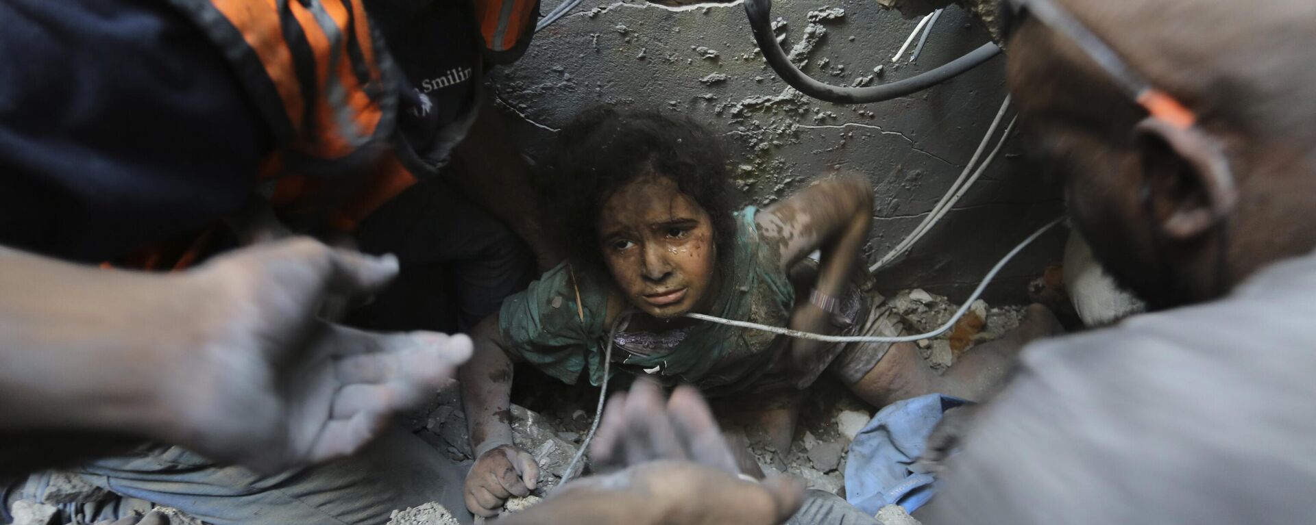 Người Palestine cố gắng kéo một bé gái ra khỏi đống đổ nát của một tòa nhà bị phá hủy bởi các cuộc không kích của Israel tại trại tị nạn Jabaliya, phía bắc Gaza. - Sputnik Việt Nam, 1920, 13.11.2023