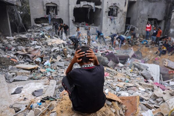 Đứa trẻ giữa đống đổ nát của tòa nhà bị hư hại sau những trận tấn công vào Rafah ở phía nam Dải Gaza - Sputnik Việt Nam