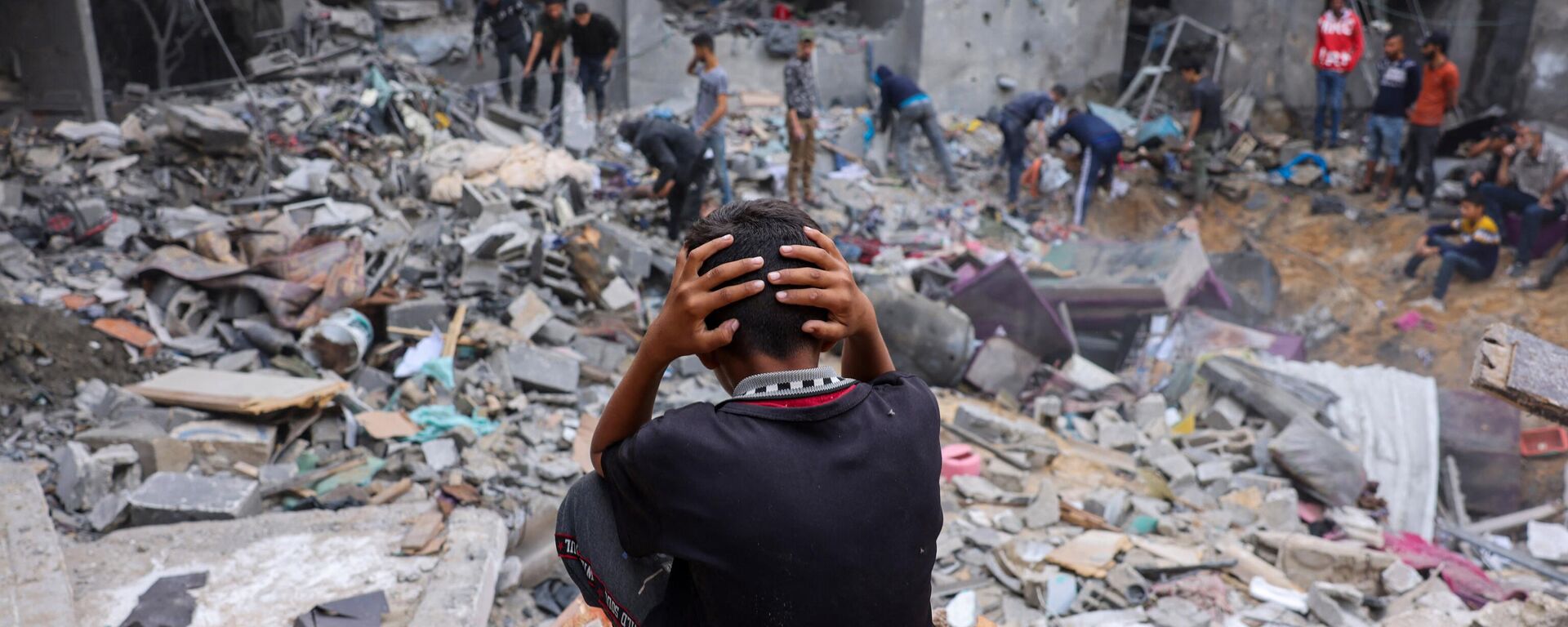 Đứa trẻ giữa đống đổ nát của tòa nhà bị hư hại sau những trận tấn công vào Rafah ở phía nam Dải Gaza - Sputnik Việt Nam, 1920, 13.11.2023