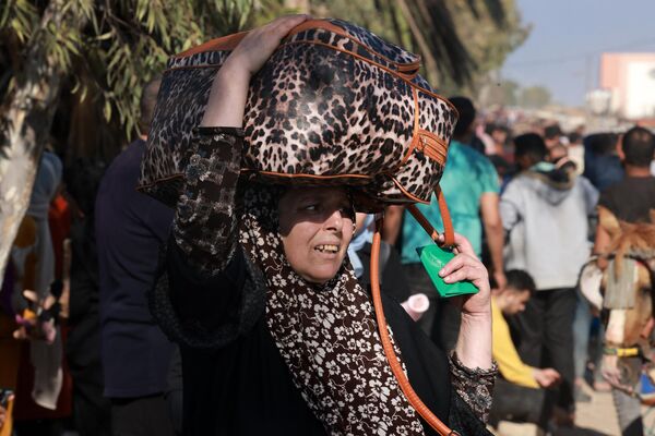 Một người phụ nữ cùng những người Palestine khác trốn khỏi thành phố Gaza bằng cách đi bộ dọc theo con đường dẫn đến phần phía nam của vùng đất - Sputnik Việt Nam