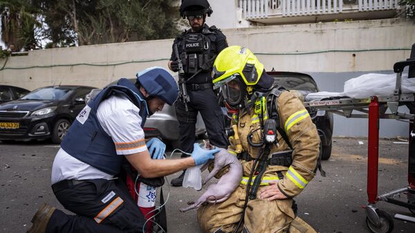Lính cứu hỏa và nhân viên y tế cung cấp oxy cho con mèo bị thương được giải cứu khỏi tòa nhà trúng tên lửa bắn từ Dải Gaza vào Tel Aviv, Israel - Sputnik Việt Nam
