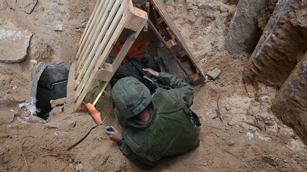 Солдат забирается в то, что, по словам израильской армии, является входом в туннель, вырытый боевиками ХАМАС - Sputnik Việt Nam