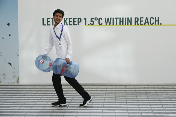 Người đàn ông mang thùng nước trước hội nghị thượng đỉnh của Liên hợp quốc COP28 về khí hậu ở Dubai - Sputnik Việt Nam