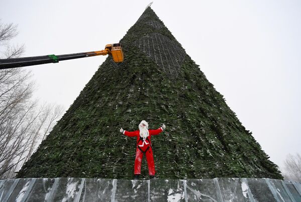 Người leo núi mặc trang phục ông già Giáng sinh lắp đặt cây thông Noel cao 57 mét trên đảo Tatyshev ở Krasnoyarsk, LB Nga - Sputnik Việt Nam