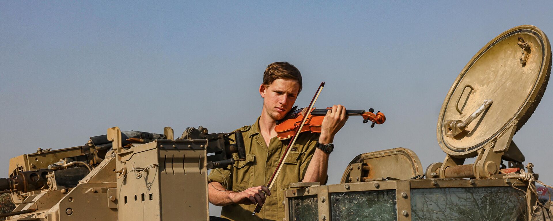 Một người lính Israel chơi violin trong một chiếc xe tăng ở phía nam Israel gần biên giới với Dải Gaza - Sputnik Việt Nam, 1920, 07.01.2024