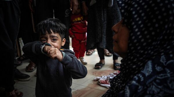 Một đứa trẻ khóc trong khi Israel ném bom bệnh viện Nasser ở Khan Yunis, phía nam Dải Gaza - Sputnik Việt Nam
