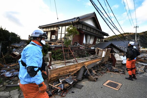 Lính cứu hỏa kiểm tra những ngôi nhà gỗ bị sập ở Wajima, tỉnh Ishikawa - Sputnik Việt Nam