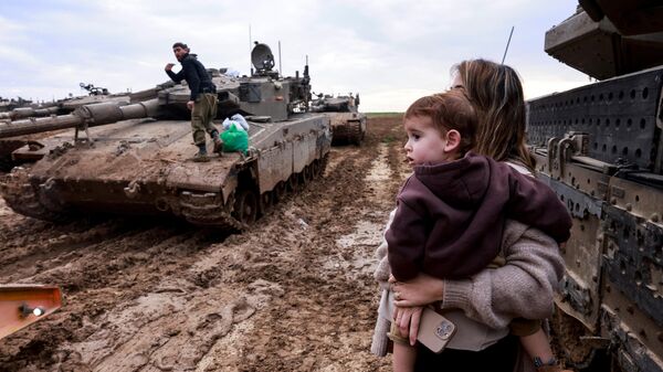 Vợ của một người lính Israel với đứa trẻ đến thăm chồng sau khi anh ta trở về từ nhiệm vụ ở lãnh thổ Palestine, biên giới với Dải Gaza - Sputnik Việt Nam