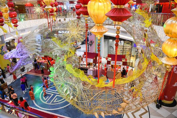 Mọi người tụ tập gần tác phẩm sắp đặt con rồng dài 152,5 mét trưng bày trước Tết Nguyên đán tại một trung tâm mua sắm ở khu phố Tàu, Manila. - Sputnik Việt Nam