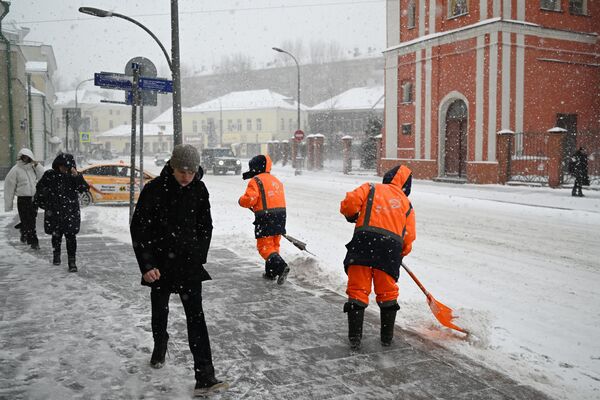 Người dân băng qua đường khi tuyết rơi ở Matxcơva. - Sputnik Việt Nam
