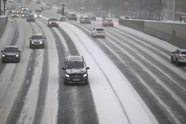 Ôtô di chuyển trên đường phố Matxcơva trong cơn bão tuyết. - Sputnik Việt Nam