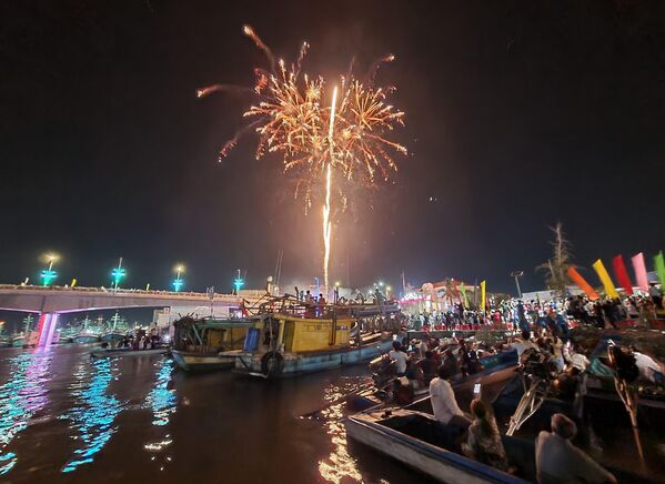 Người dân nơi cửa biển Sông Đốc đi xuồng đến địa điểm tổ chức chương trình nghệ thuật và bắn pháo hoa chào đón năm mới 2024. - Sputnik Việt Nam