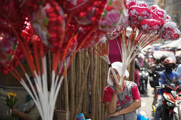 Người phụ nữ bán bóng bay tại chợ hoa trong ngày lễ tình nhân ở Manila, Philippines. - Sputnik Việt Nam