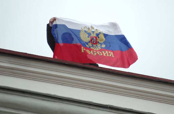 Người dân địa phương treo cờ Nga trên nóc Hội đồng thành phố ở Sevastopol - Sputnik Việt Nam