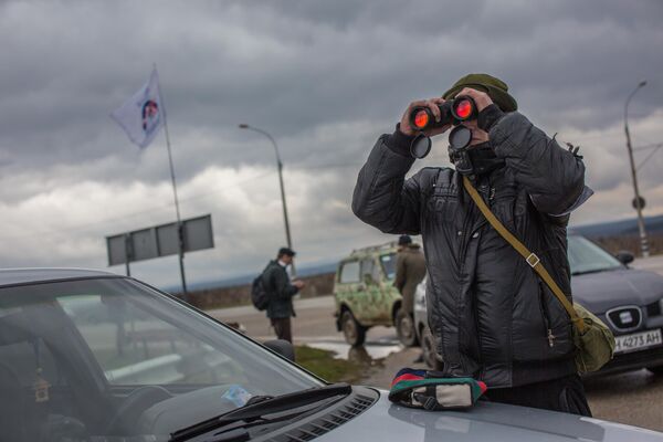 Người dân địa phương theo dõi trạm kiểm soát quân sự ở lối vào sân bay Belbek gần Sevastopol - Sputnik Việt Nam