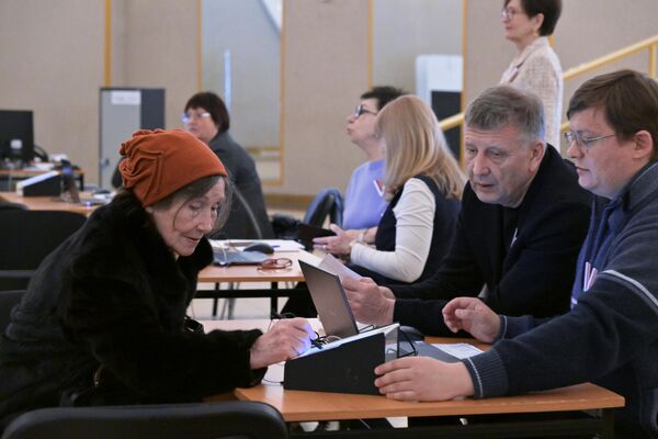 Thành viên ban bầu cử khu vực đăng ký cho người phụ nữ tham gia cuộc bầu cử tổng thống Nga ở Moskva - Sputnik Việt Nam