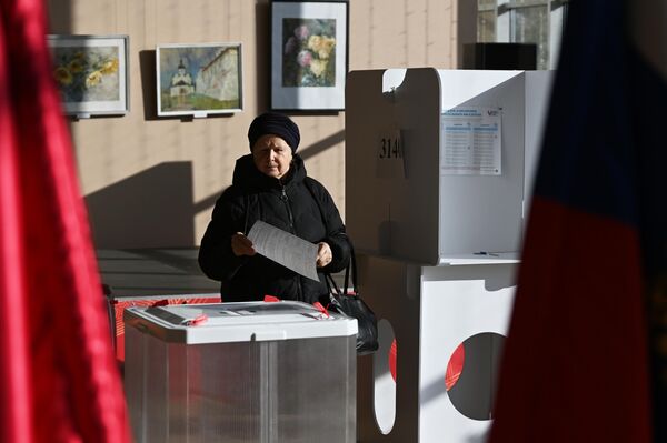 Người phụ nữ bỏ phiếu trong cuộc bầu cử tổng thống Nga tại một điểm bầu cử ở Moskva - Sputnik Việt Nam