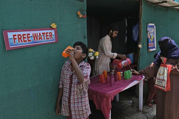 Tình nguyện viên phân phát nước uống gần trạm xe buýt vào một ngày hè nóng nực ở Hyderabad, Ấn Độ - Sputnik Việt Nam