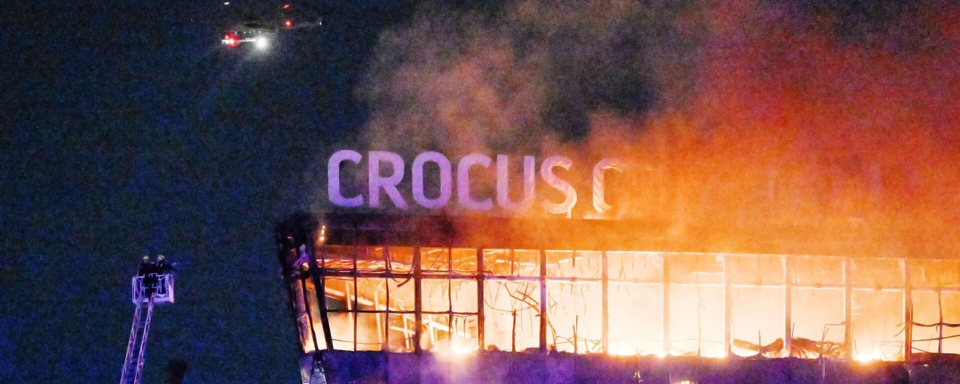 Lính cứu hỏa dập tắt mái nhà cháy của nhà hát Crocus City Hall, nơi vụ nổ súng xảy ra. - Sputnik Việt Nam, 1920, 08.04.2024