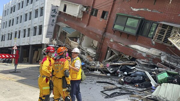 Các thành viên đội tìm kiếm, cứu hộ gần tòa nhà nghiêng sau trận động đất ở Hoa Liên, miền đông Đài Loan, Trung Quốc - Sputnik Việt Nam