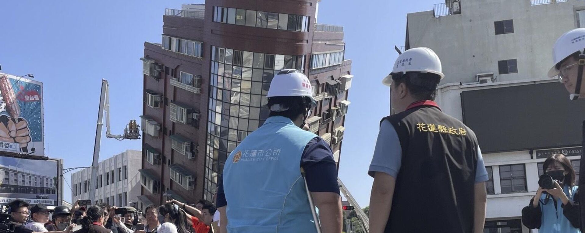 Các quan chức chính phủ và nhà báo bên cạnh lính cứu hỏa làm việc gần tòa nhà nghiêng sau trận động đất ở Hoa Liên, miền đông Đài Loan, Trung Quốc - Sputnik Việt Nam, 1920, 03.04.2024