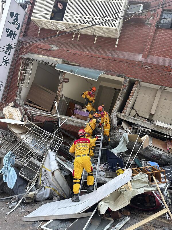 Các thành viên của đội tìm kiếm, cứu hộ gần tòa nhà bị phá hủy sau trận động đất ở Hoa Liên, miền đông Đài Loan, Trung Quốc - Sputnik Việt Nam