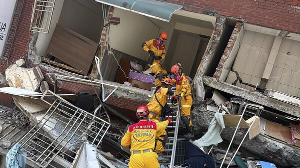 Các thành viên của đội tìm kiếm, cứu hộ gần tòa nhà bị phá hủy sau trận động đất ở Hoa Liên, miền đông Đài Loan, Trung Quốc - Sputnik Việt Nam