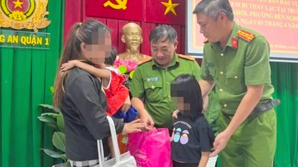 Lực lượng Công an Thành phố Hồ Chí Minh trao trả hai cháu bé về với gia đình chị Nguyễn Thị Chi.  - Sputnik Việt Nam