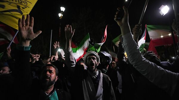 Iranian demonstrators chant slogans during an anti-Israeli gathering in front of the British Embassy in Tehran, Iran, early Sunday, April 14, 2024. Iran launched its first direct military attack against Israel on Saturday. - Sputnik Việt Nam