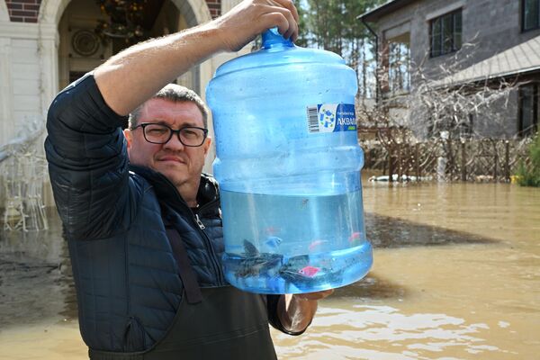 Người dân địa phương đang sơ tán khỏi ngôi nhà bị ngập lụt ở làng Nezhinka, tỉnh Orenburg - Sputnik Việt Nam