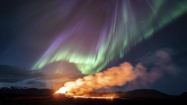 Вид на зону извержения вулкана на фоне северного сияния, Гриндавик, Исландия - Sputnik Việt Nam