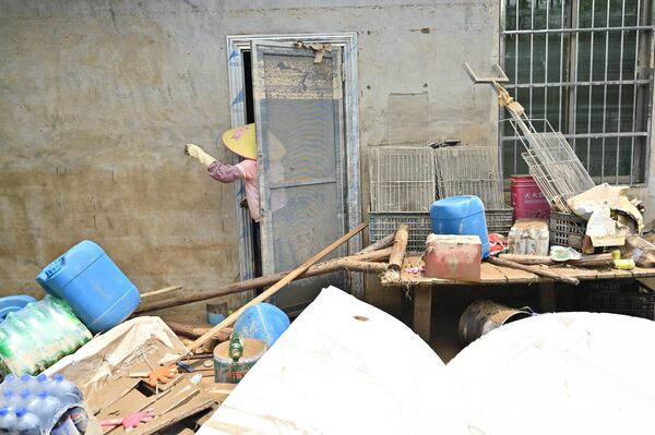 Công nhân dọn dẹp tòa nhà sau khi mưa lớn làm ngập lụt địa bàn làng Sa Tân ở Thanh Viễn, phía bắc của tỉnh Quảng Đông, Trung Quốc - Sputnik Việt Nam