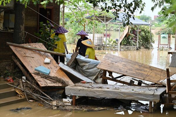 Công nhân dọn dẹp phòng khách sạn sau khi mưa lớn làm ngập lụt địa bàn làng Sa Tân ở Thanh Viễn, phía bắc của tỉnh Quảng Đông, Trung Quốc - Sputnik Việt Nam