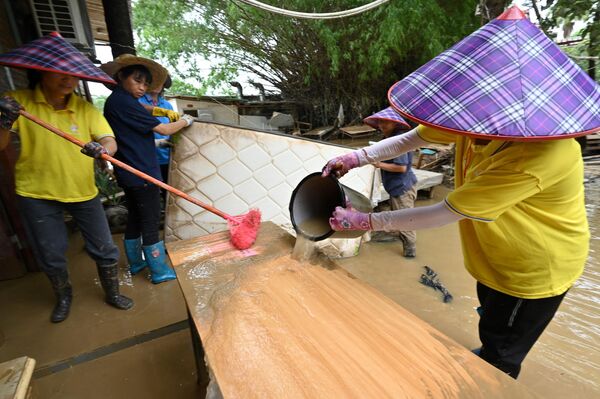 Công nhân dọn tấm nệm và bàn ghế ra khỏi phòng khách sạn sau khi mưa lớn làm ngập địa bàn làng Sa Tân ở Thanh Viễn, phía bắc của tỉnh Quảng Đông, Trung Quốc - Sputnik Việt Nam