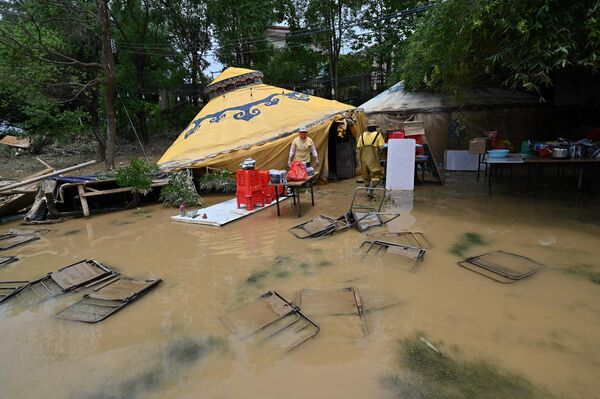 Công nhân thu dọn đồ đạc sau khi mưa lớn làm ngập lụt khu vực Thanh Viễn, phía bắc của tỉnh Quảng Đông, Trung Quốc - Sputnik Việt Nam