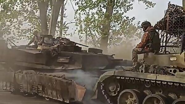 Các binh sĩ của nhóm Trung tâm sơ tán chiếc xe tăng Abrams đầu tiên khỏi khu vực Avdeevka của mặt trận - Sputnik Việt Nam