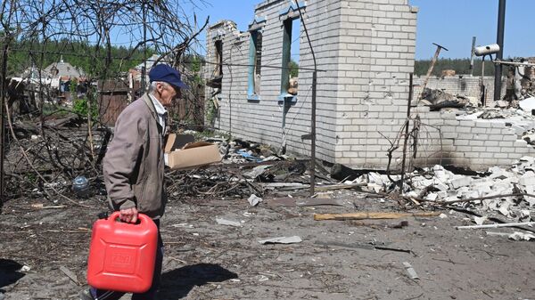 Người đàn ông cạnh tòa nhà dân cư bị hư hại do pháo kích ở làng Liman 1, tỉnh Kharkov - Sputnik Việt Nam